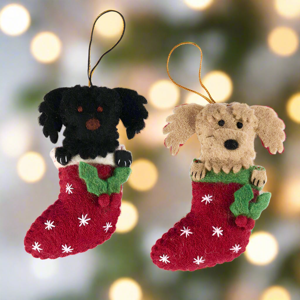 Two dog-themed Christmas stockings with black and brown dogs on a white background