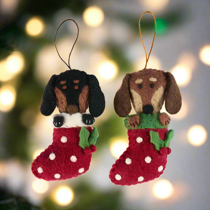 Two dog-shaped Christmas stockings with red backgrounds on a white background