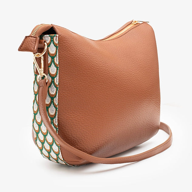 Brown leather handbag with a patterned strap on a white background