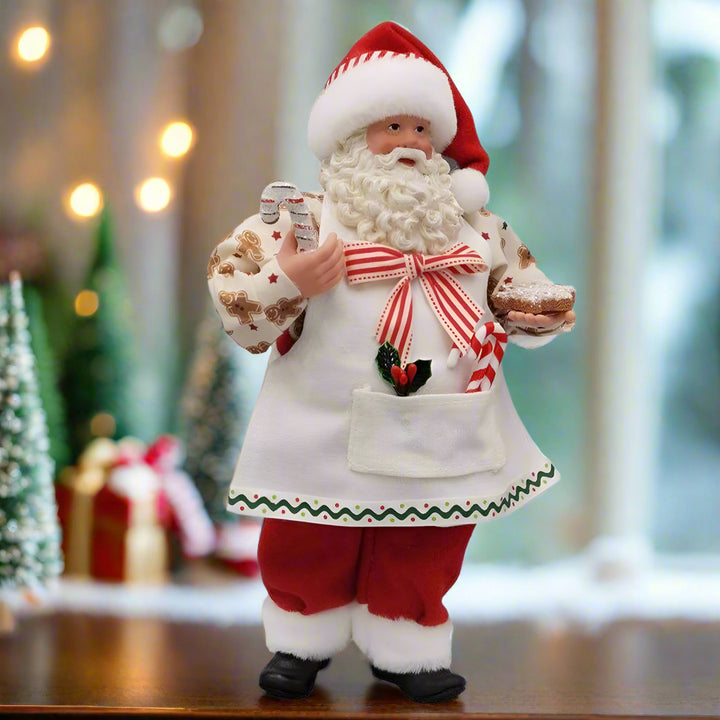 Decorative figure of Santa Claus holding a gift on a white background