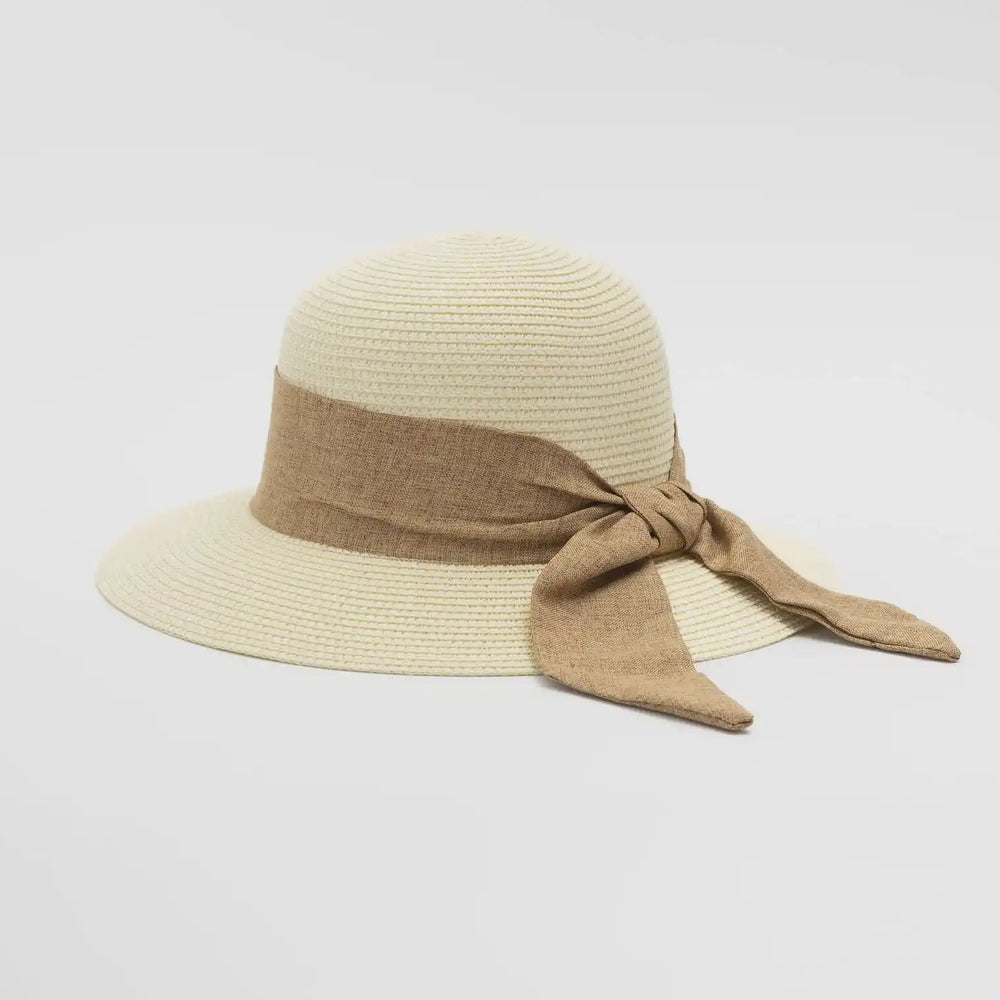 Beige sun hat with a brown ribbon on a light gray background