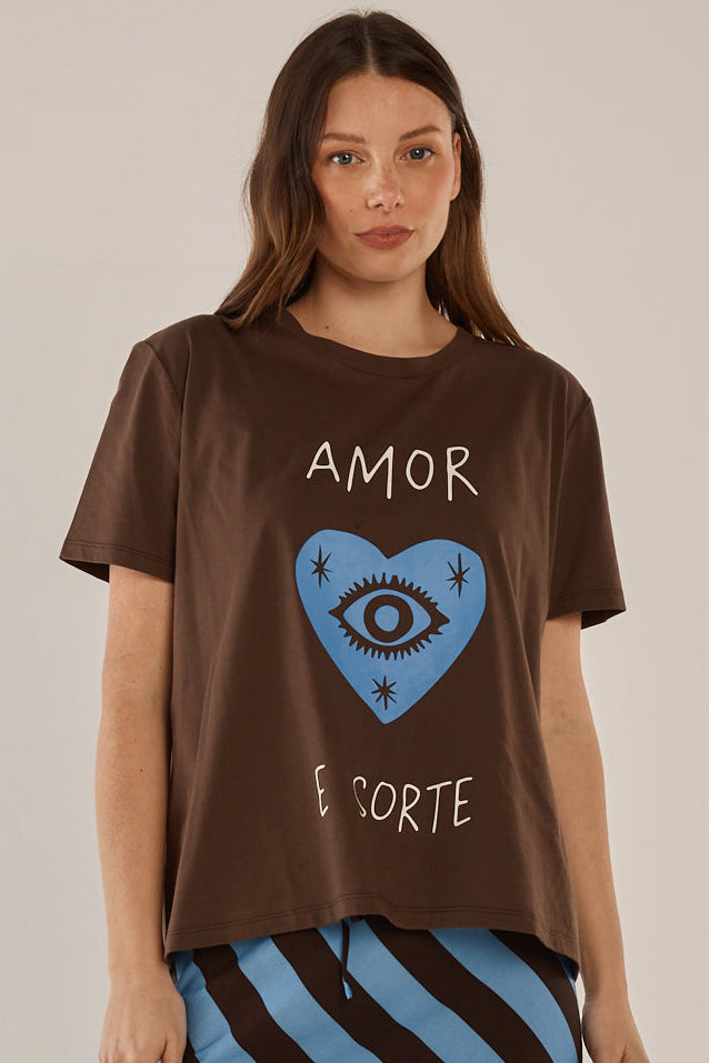 Woman wearing a brown t-shirt with a graphic design and text on a plain background