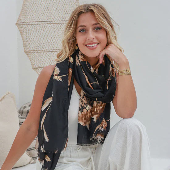 Woman wearing a black floral scarf in a white room