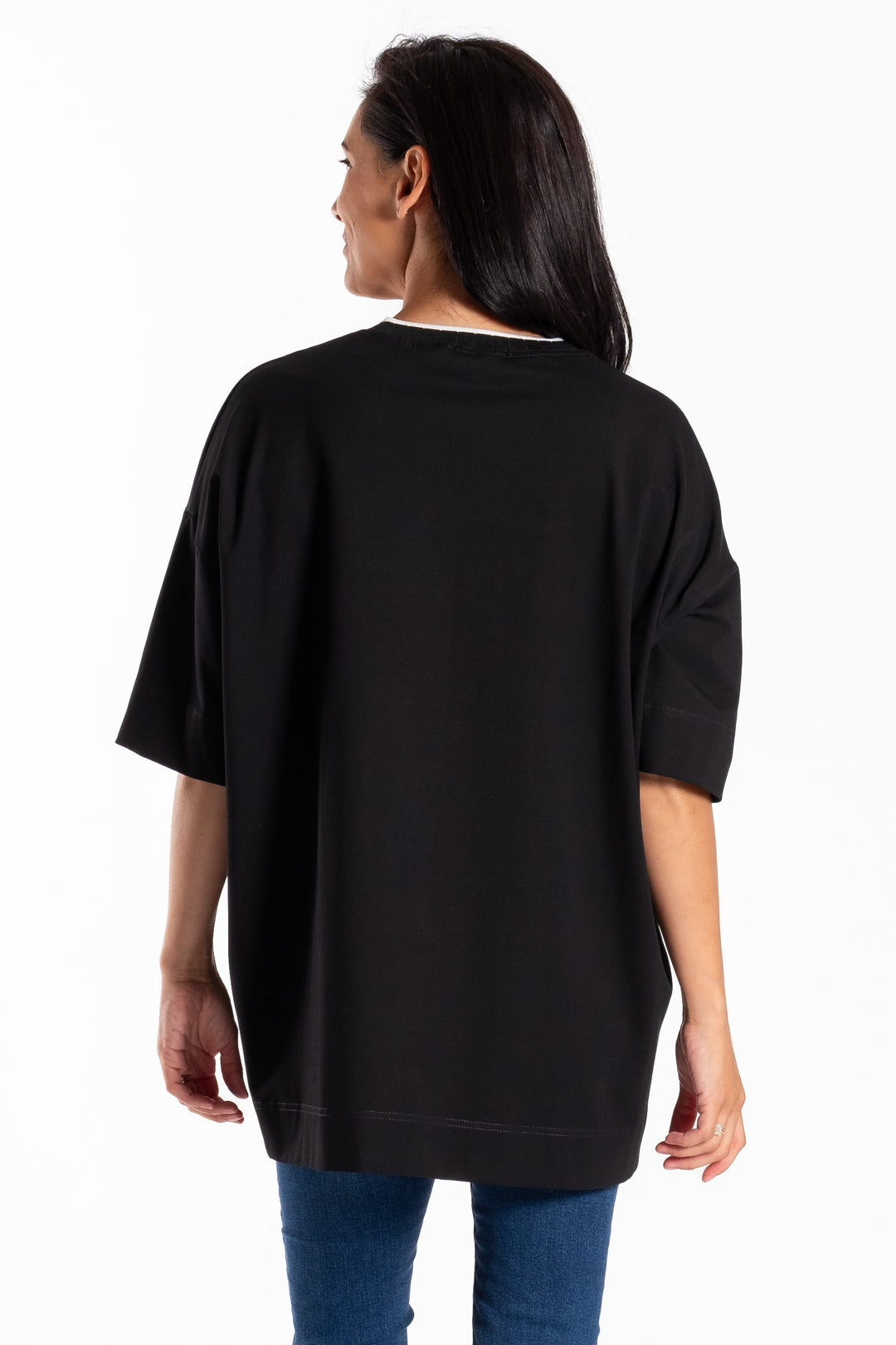 Person wearing a black oversized jellicoe t-shirt and blue jeans on a white background