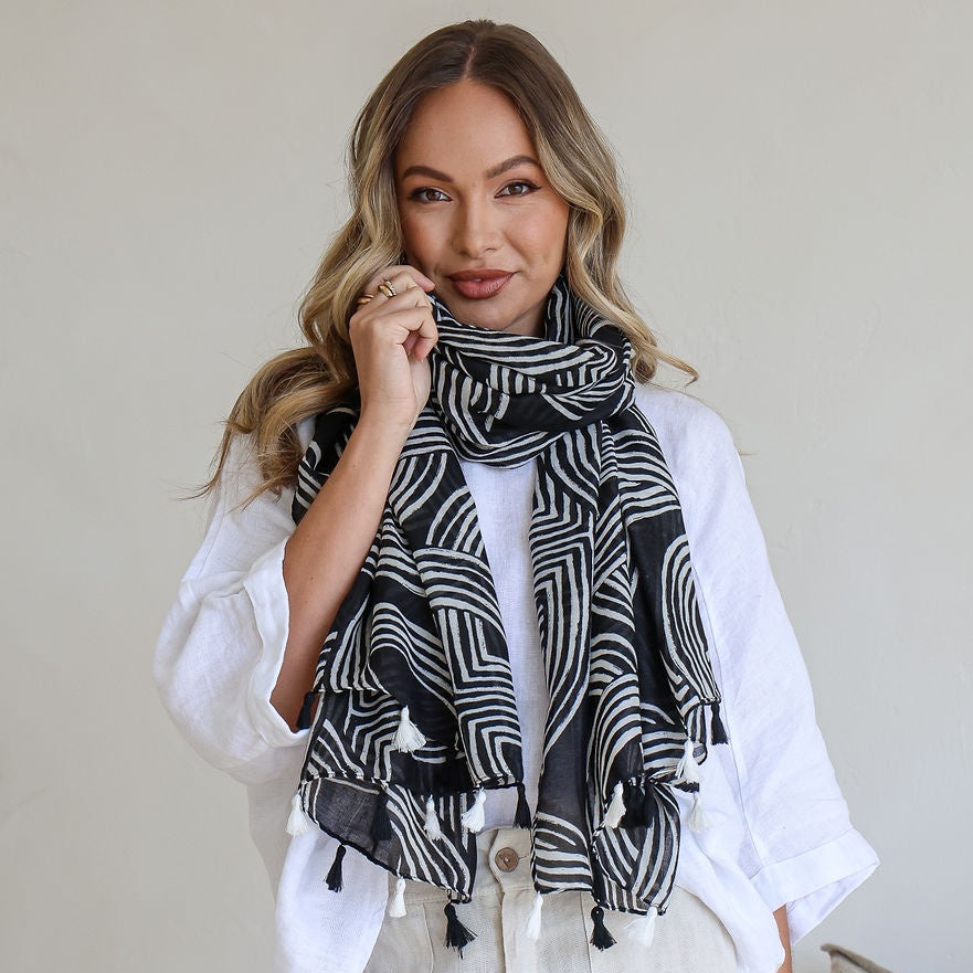 Woman wearing a black and white patterned scarf in a casual setting