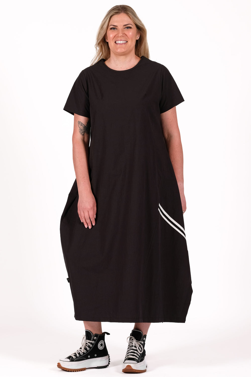 Person wearing a black dress with white stripes on a white background