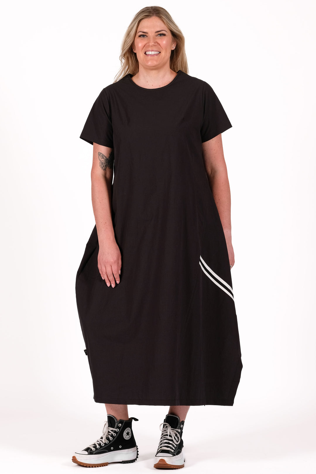 Person wearing a black dress with white stripes on a white background