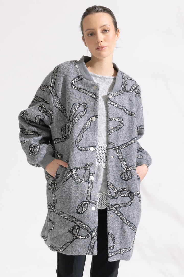 Person wearing a patterned gray coat on a white background