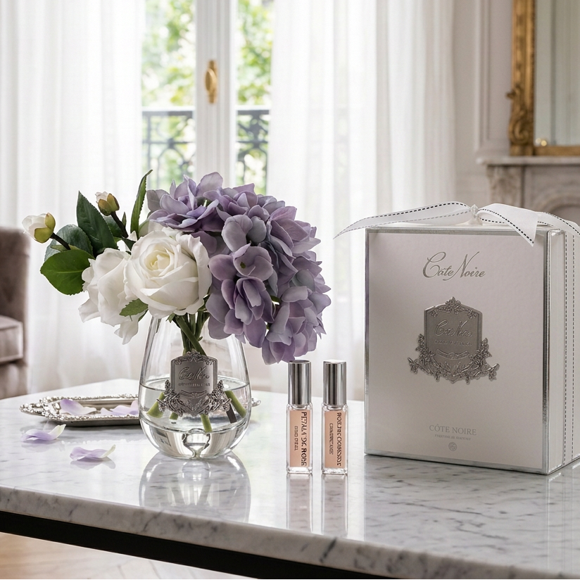 Perfume set with flowers and packaging on a white table in luxury room