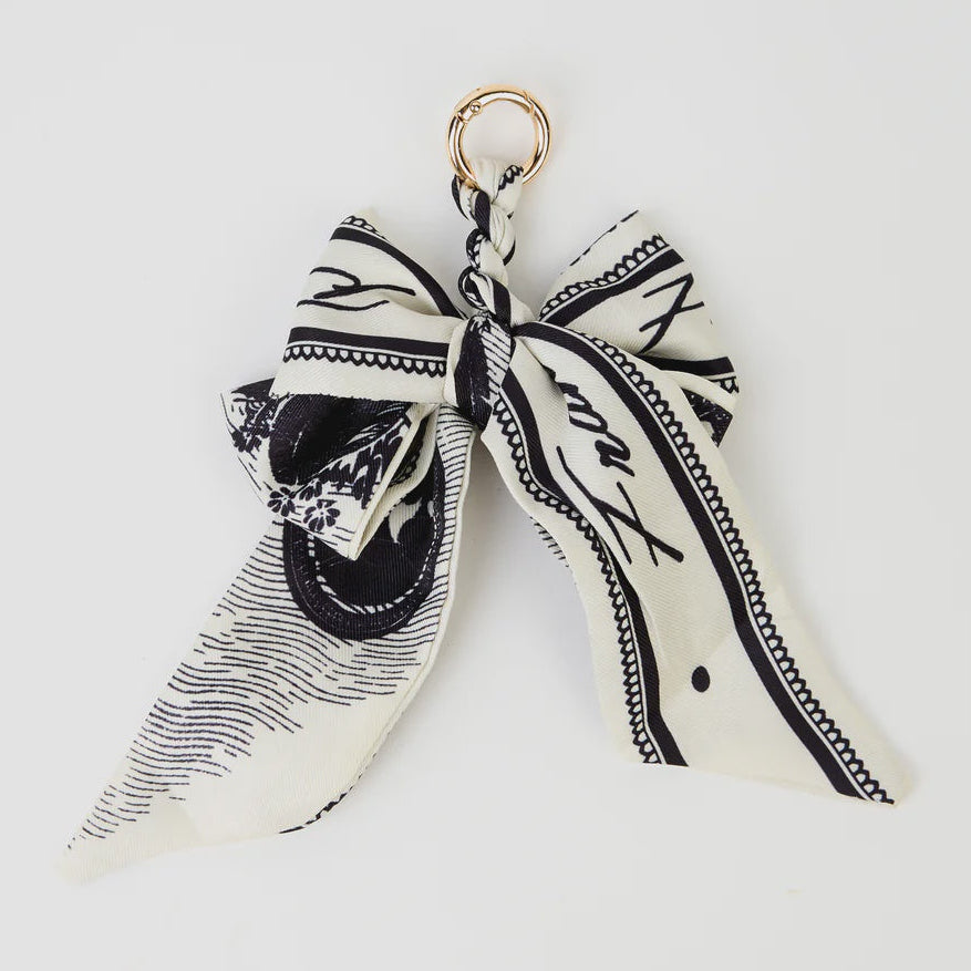 Black and white patterned bow keychain on a light gray background