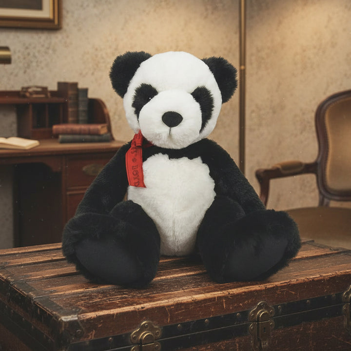 Plush panda bear with a red tag on a light gray background