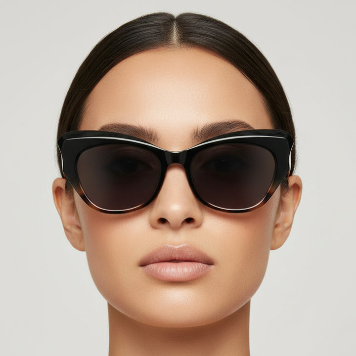 Black cat-eye sunglasses with a gray gradient lens on a light gray background