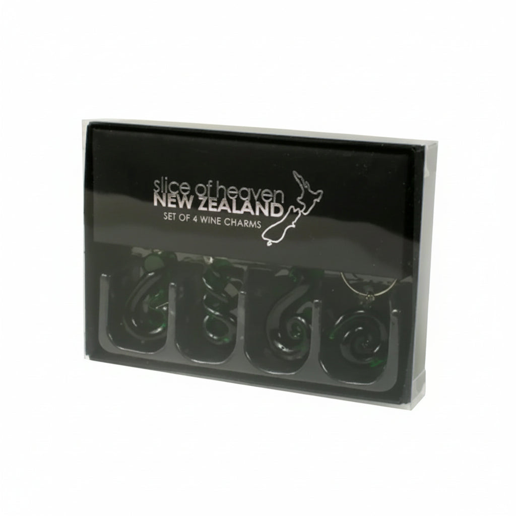 A black gift box containing four dark green spiral-shaped wine charms, with 'slice of heaven NEW ZEALAND' printed in white on the lid.
