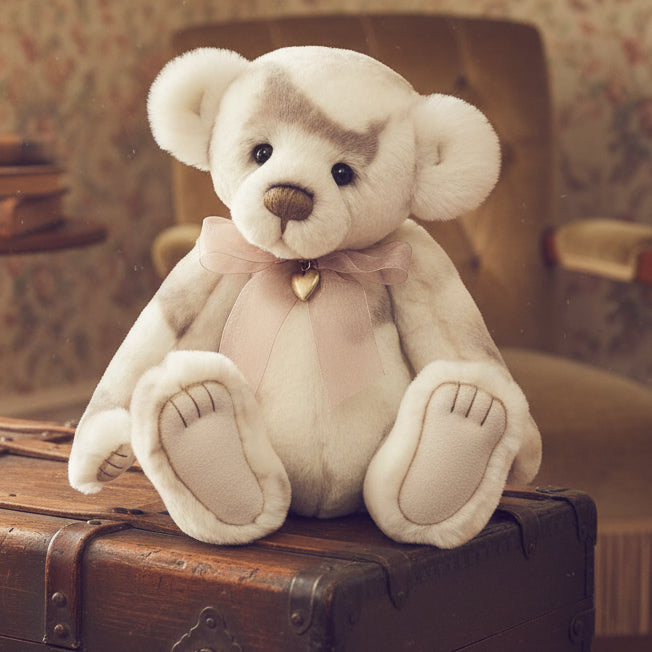 Plush charlie bears collectable teddy bear with a pink bow and heart charm on a white background