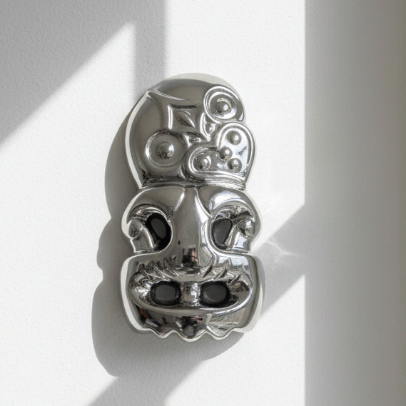 Metallic skull-shaped object on a white background