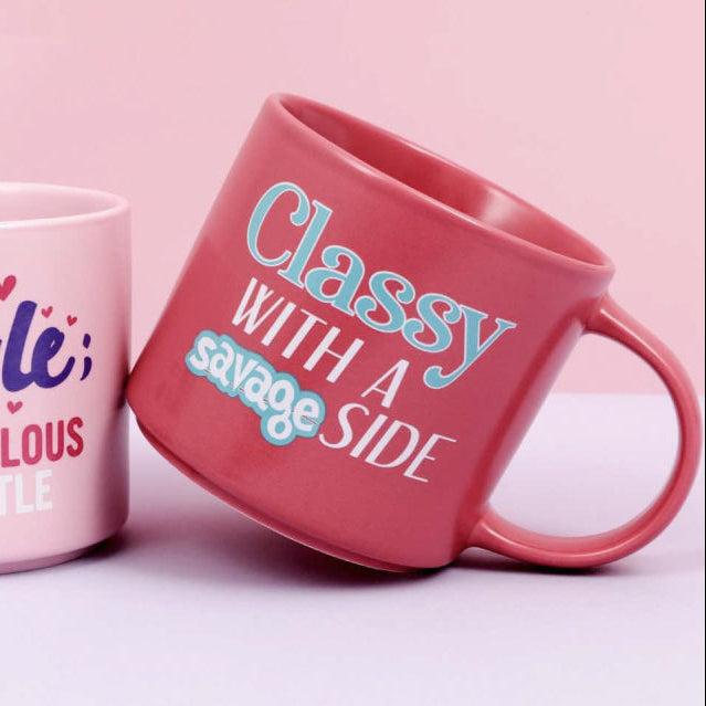 Two pink mugs with motivational phrases on a pink background
