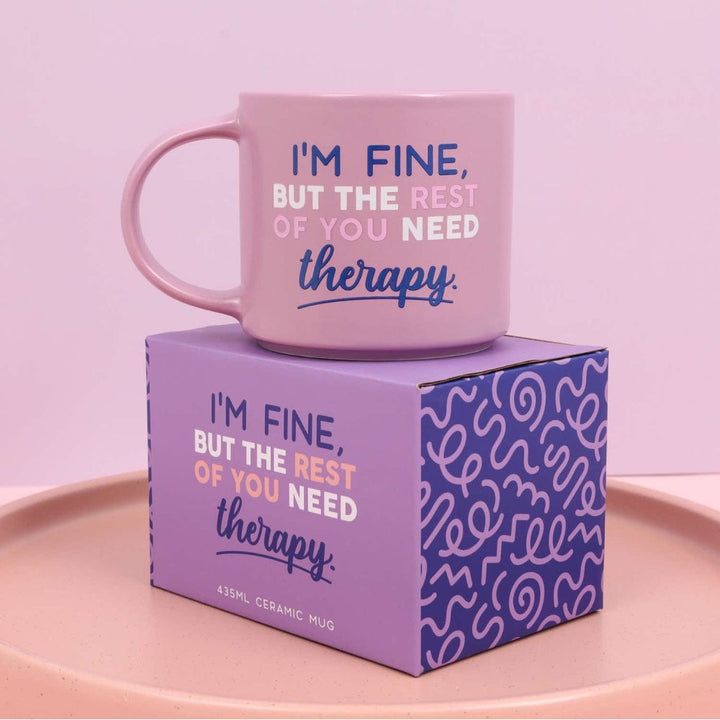 Purple mug with funny text on a purple box against a light pink background
