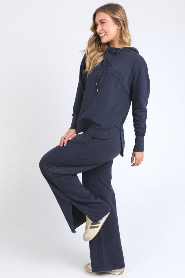 Woman wearing a navy blue hoodie and pants on a white background