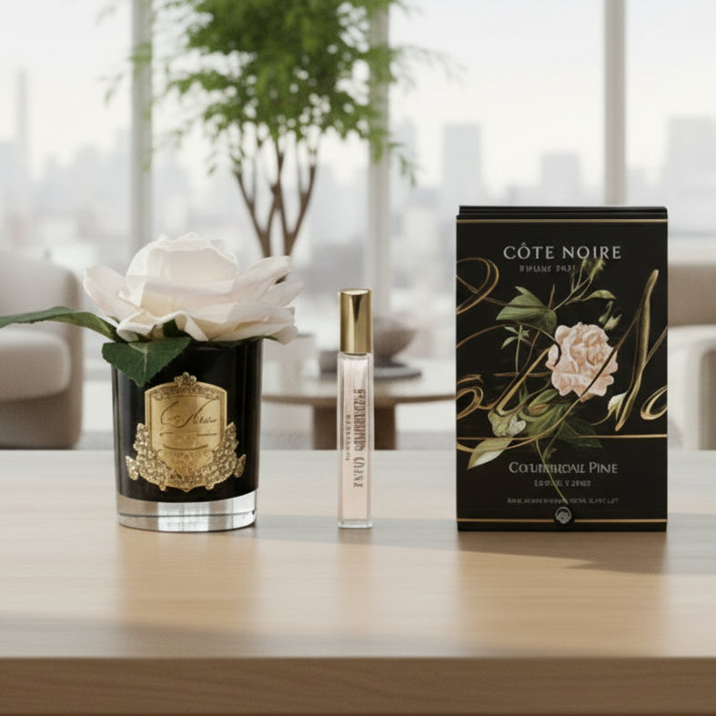 Cote Noire perfume set with a rose and packaging on a light gray background