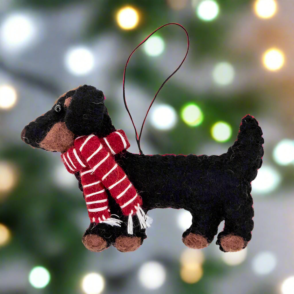 Black dog toy with a red and white striped scarf on a white background