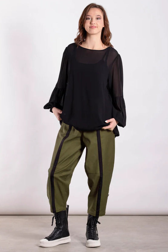 model wearing a black top and khaki green with stripe pants.