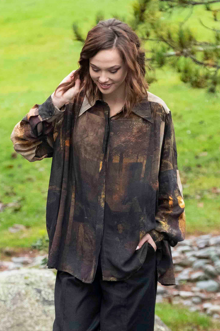 Person walking near a pond in a natural setting wearing a beautiful printed graphic buccaneer shirt from deeanne hobbs