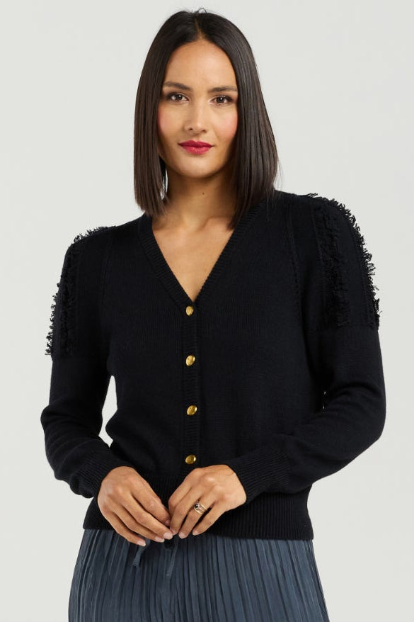 Woman wearing a black cardigan and dark ribbed pants on a white background