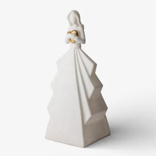 White ceramic sculpture of a figure with a flowing garment on a white background