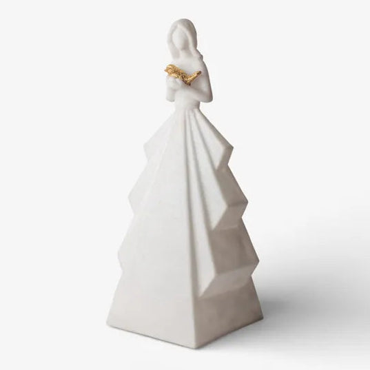 White ceramic figurine of a woman holding a heart on a white background