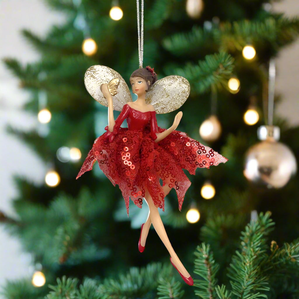 Fairy ornament with red dress and gold shoes on a white background