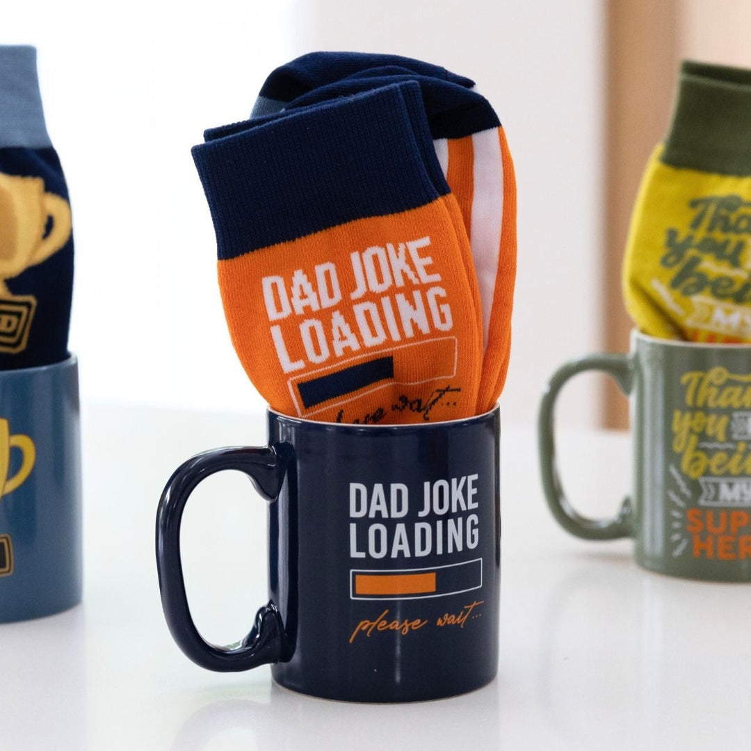 Mugs and socks with humorous text on a white surface