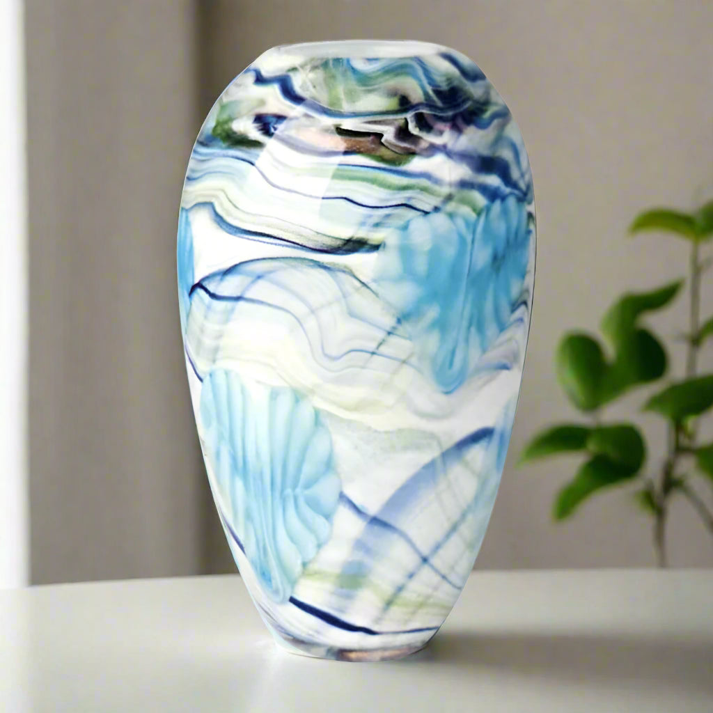 Glass vase with blue and white marbled pattern on a white background