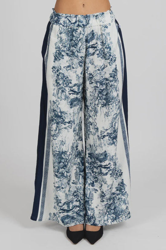 Floral-patterned pants with black side panels on a white background