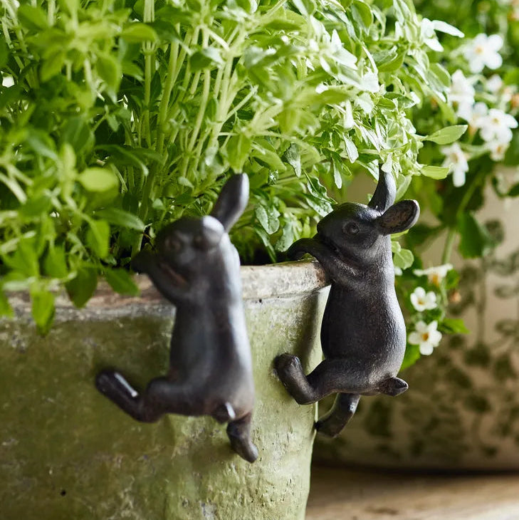 2 brown bunny ornaments hanging from a planter pot.