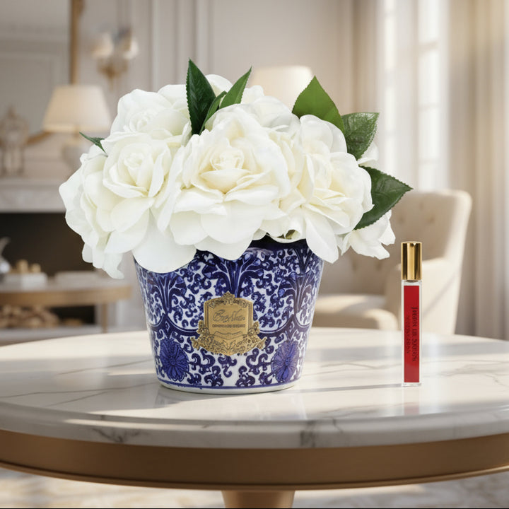 Cote Noire floral arrangement of Gardenias in a blue and white pot with a perfume for the flowers to diffuse the fragrance.