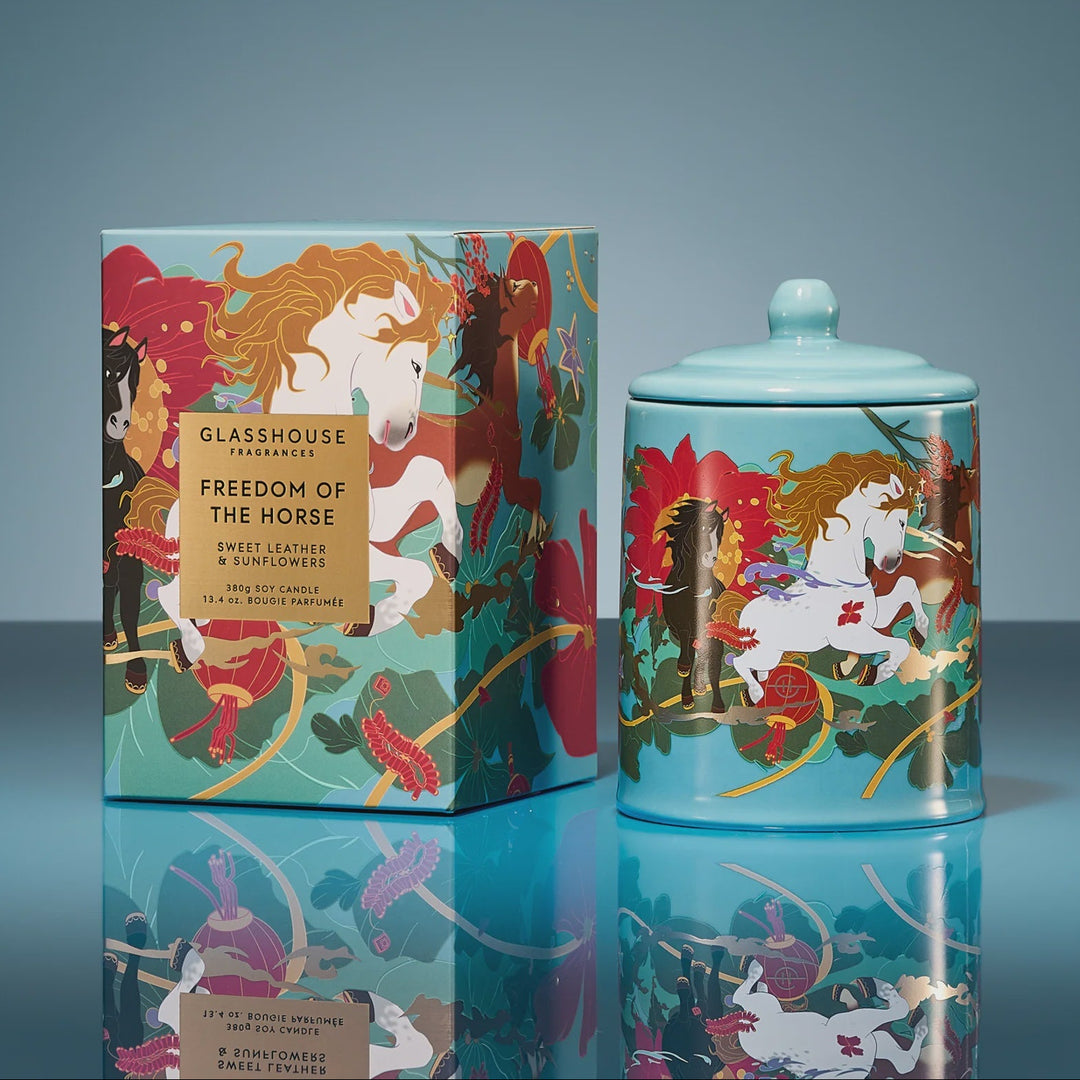 Decorative glasshouse jar and box with horse-themed design on a reflective surface.
