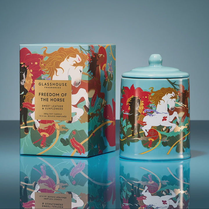 Decorative glasshouse jar and box with horse-themed design on a reflective surface.