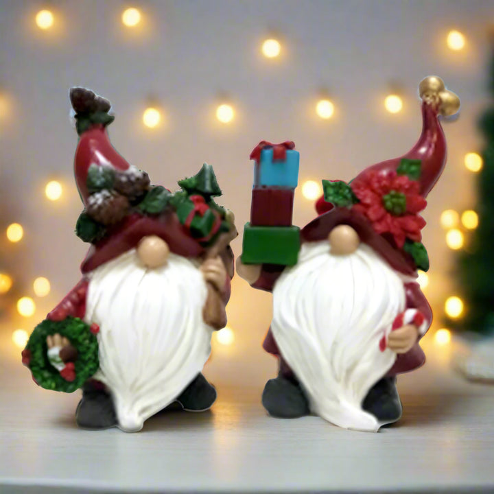 Two festive gnome figurines with holiday decorations on a white background