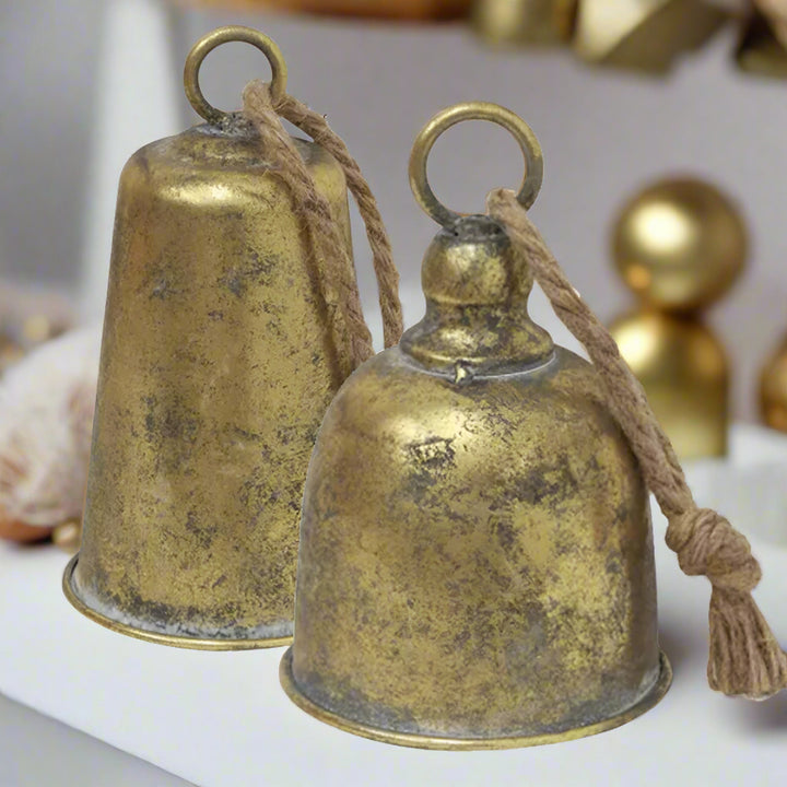 Two brass bells with ropes on a white background