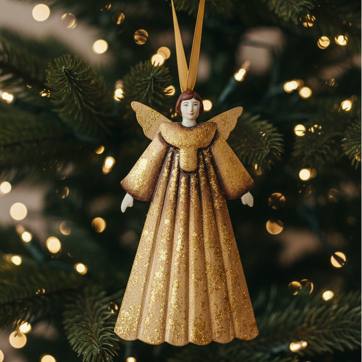 Decorative angel ornament with gold dress on a xmas tree