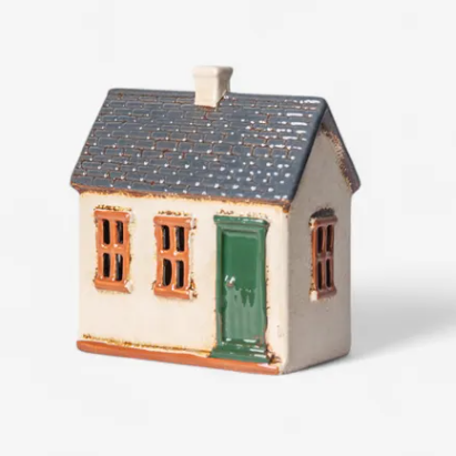 Small model of a house with a green door on a white background