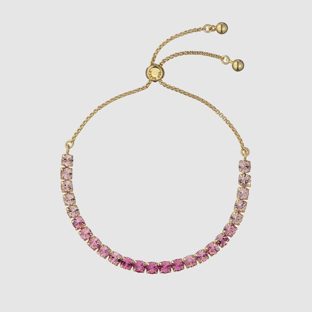 Gold bracelet with pink gemstones on a light gray background