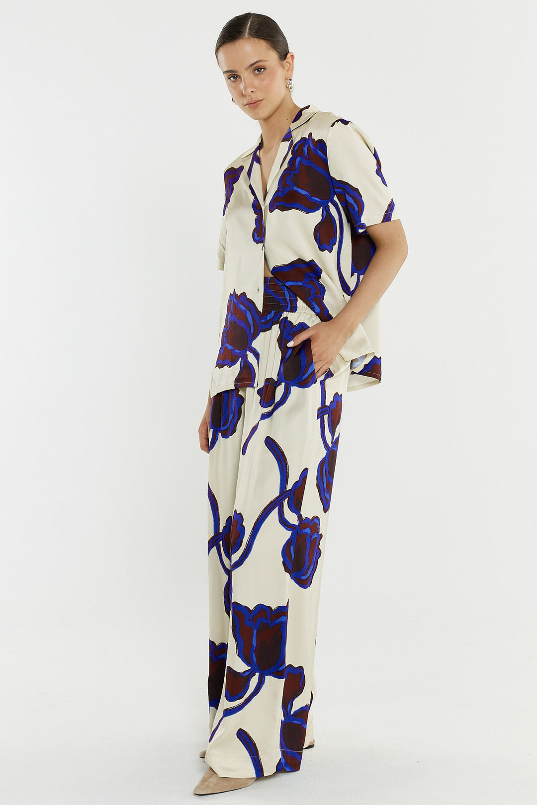 woman wearing a bold print satin pant and matching shirt.