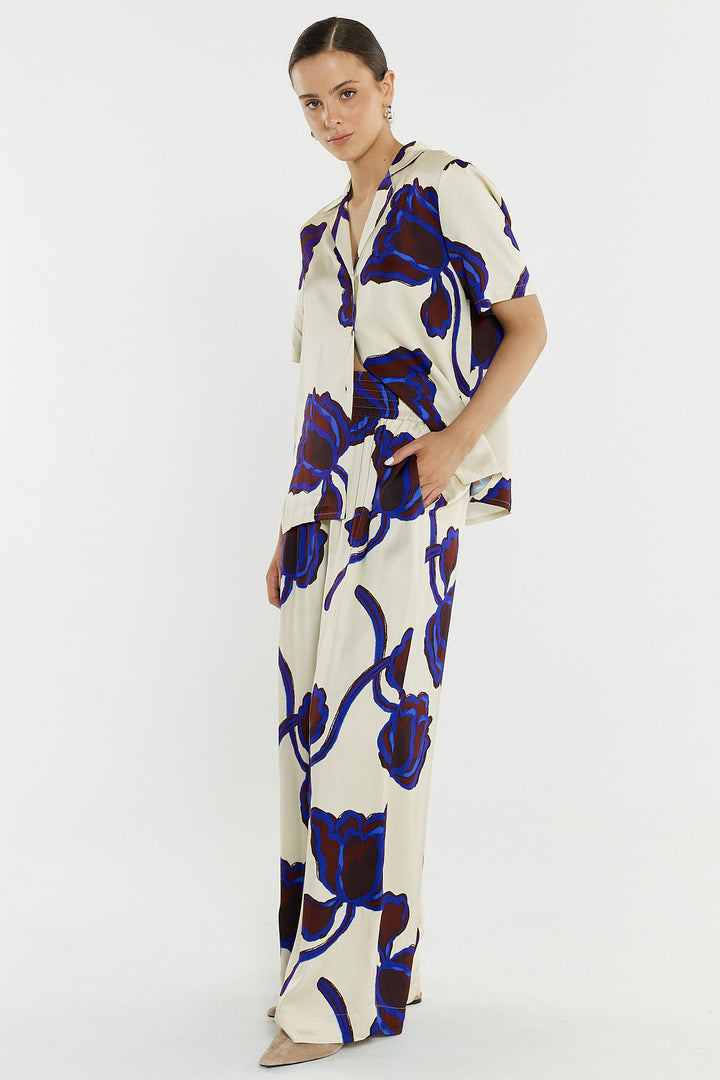 woman wearing a bold print satin pant and matching shirt.