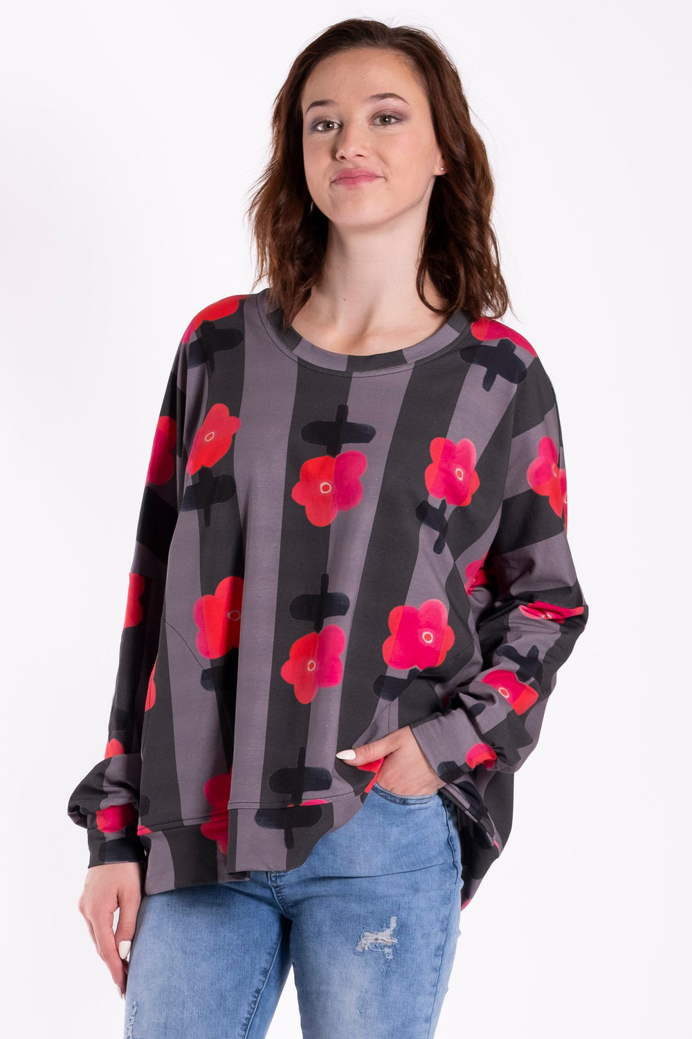 Person wearing a floral sweater and jeans on a white background