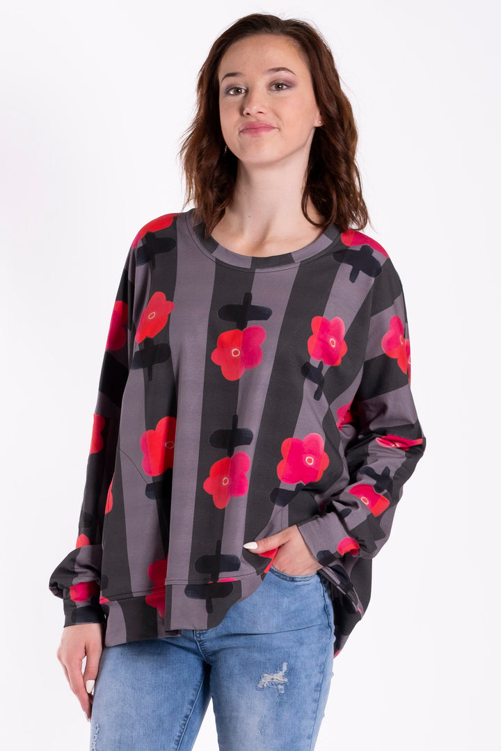 Person wearing a floral sweater and jeans on a white background