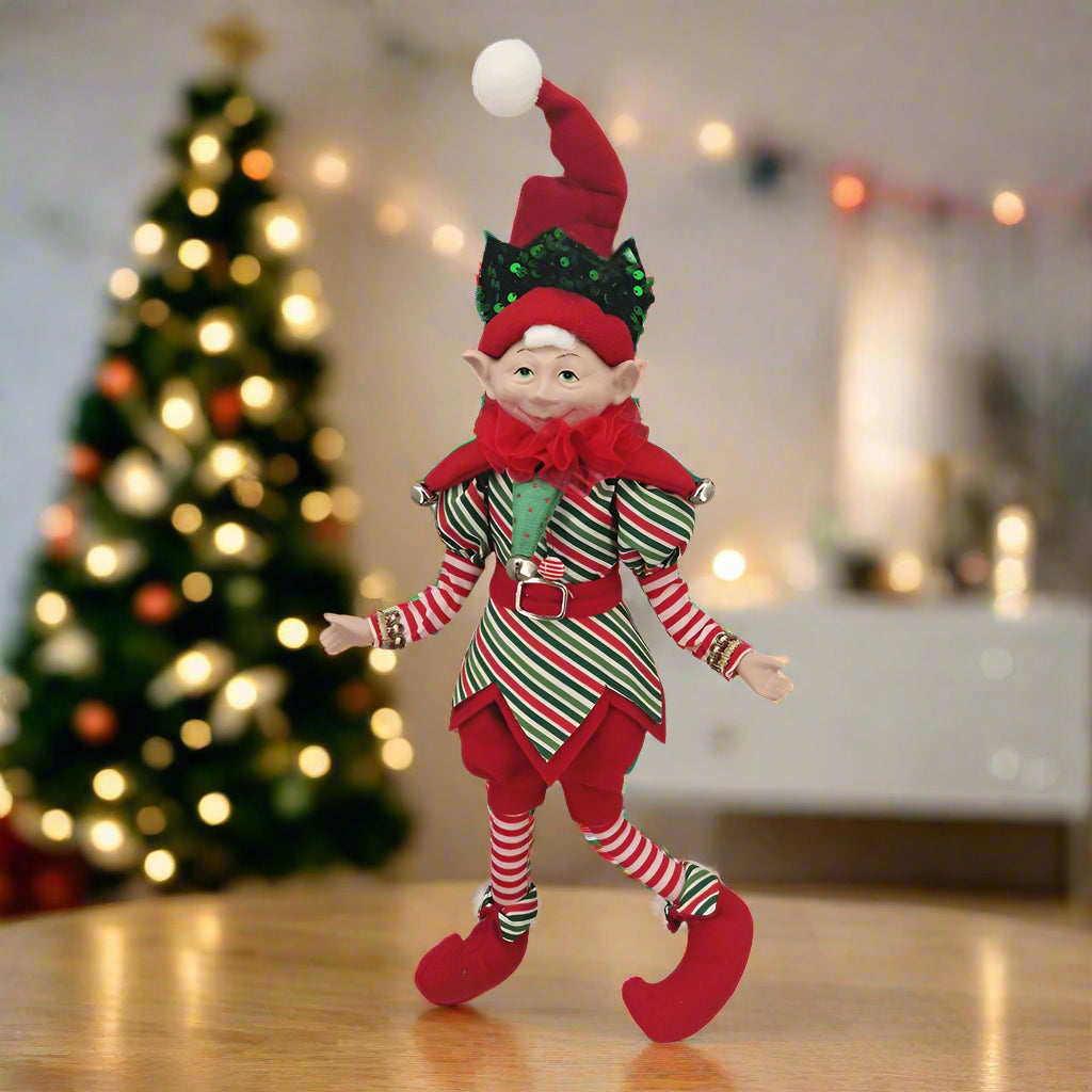 Christmas elf doll in red and green outfit on a white background