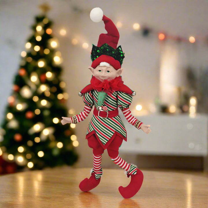 Christmas elf doll in red and green outfit on a white background