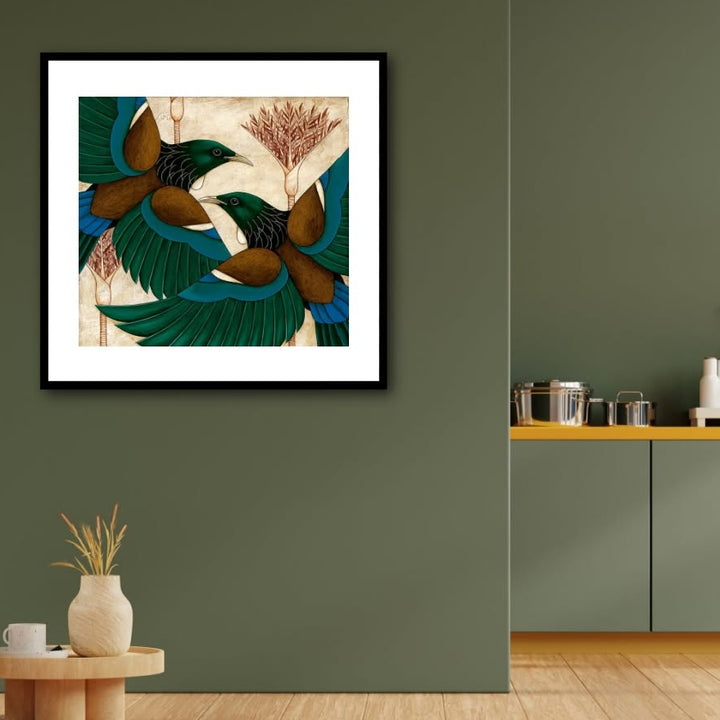 Framed abstract artwork on a green wall with a kitchen area in the background