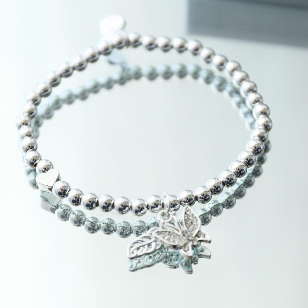 Silver bracelet with a butterfly charm on a white background